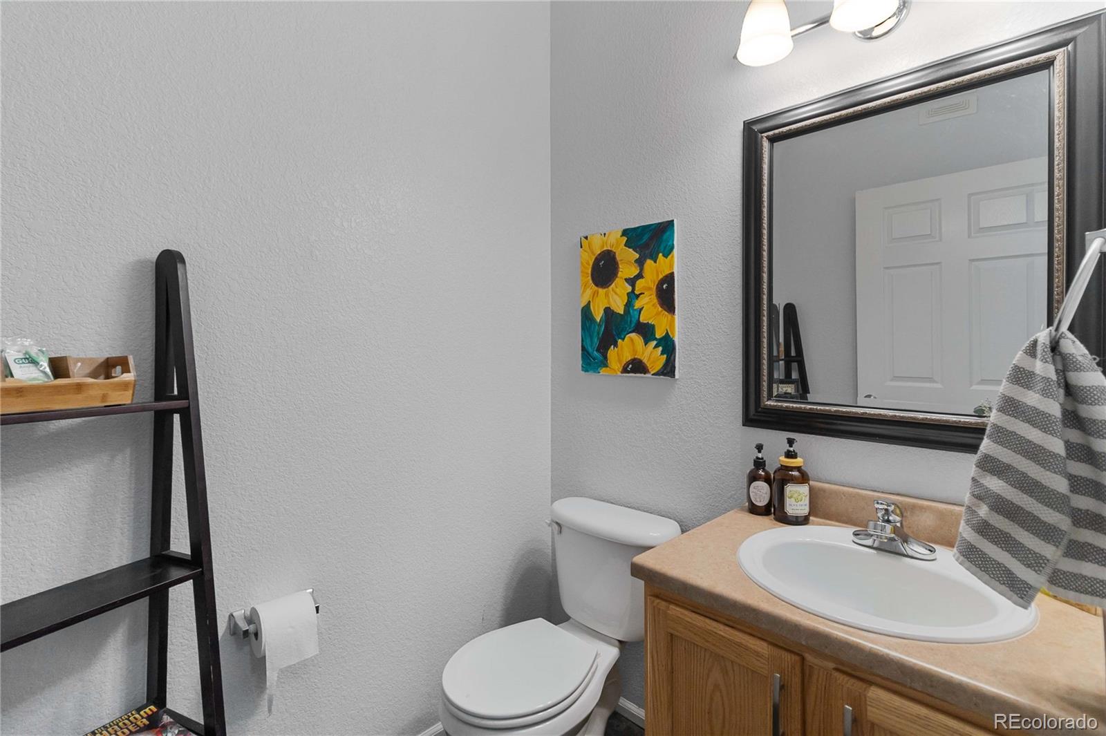 5255 Memphis Street, Unit 702 Denver, CO 80239 - Photo 13 of 30 a bathroom with a toilet sink and mirror