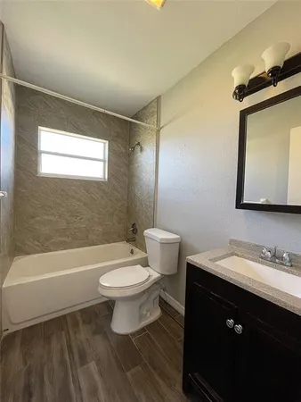 a bathroom with a sink a toilet a mirror and bathtub