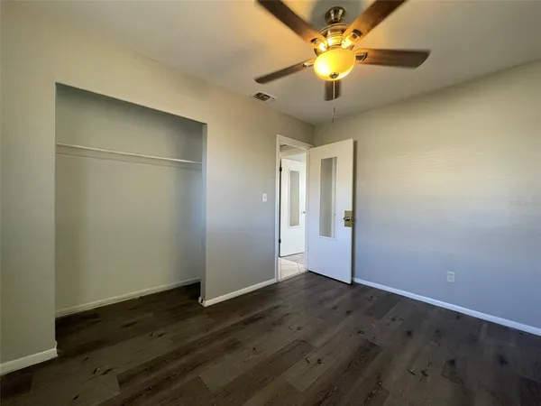 an empty room with a fan and a chandelier fan