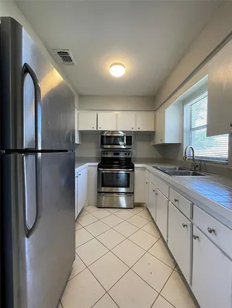 a kitchen with granite countertop a refrigerator and a sink