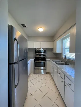 a kitchen with stainless steel appliances a refrigerator sink and cabinets