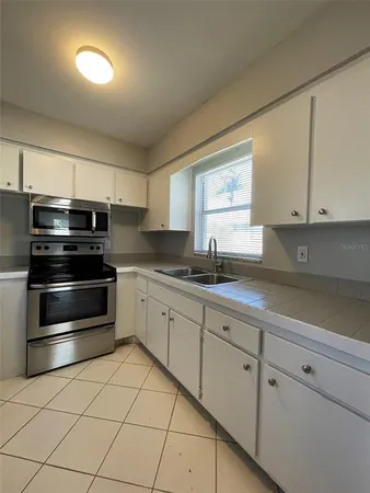 a kitchen with granite countertop white cabinets and stainless steel appliances