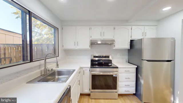 a kitchen with a refrigerator sink and cabinets