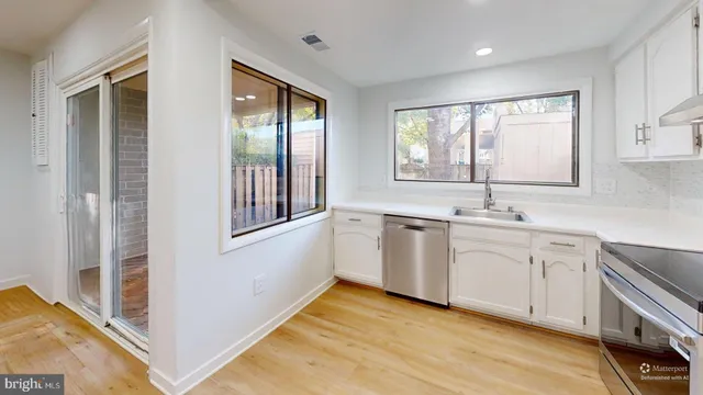a view of a kitchen with dishwasher and white cabinets