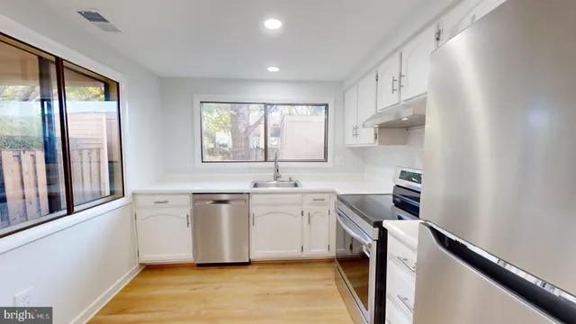 a kitchen with a sink stove top oven and cabinets