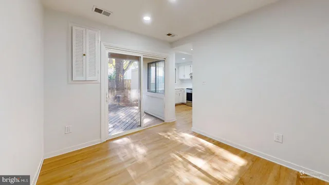 a view of a big room with wooden floor and windows