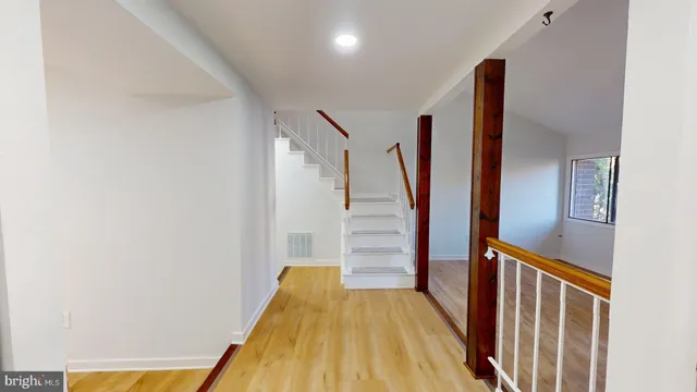 a view of a hallway with wooden floor and staircase