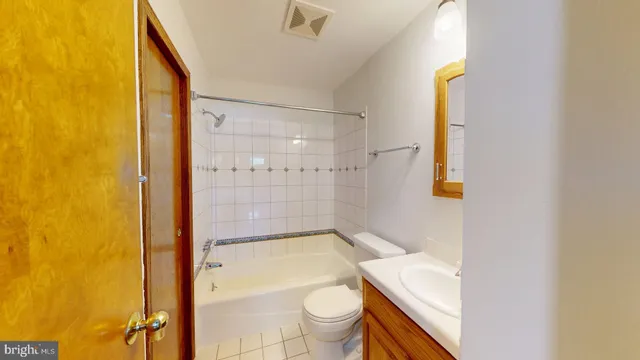 a bathroom with a granite countertop sink mirror vanity and toilet