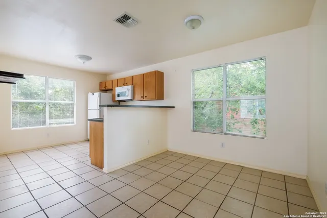 a view of a kitchen with wooden floor and a window