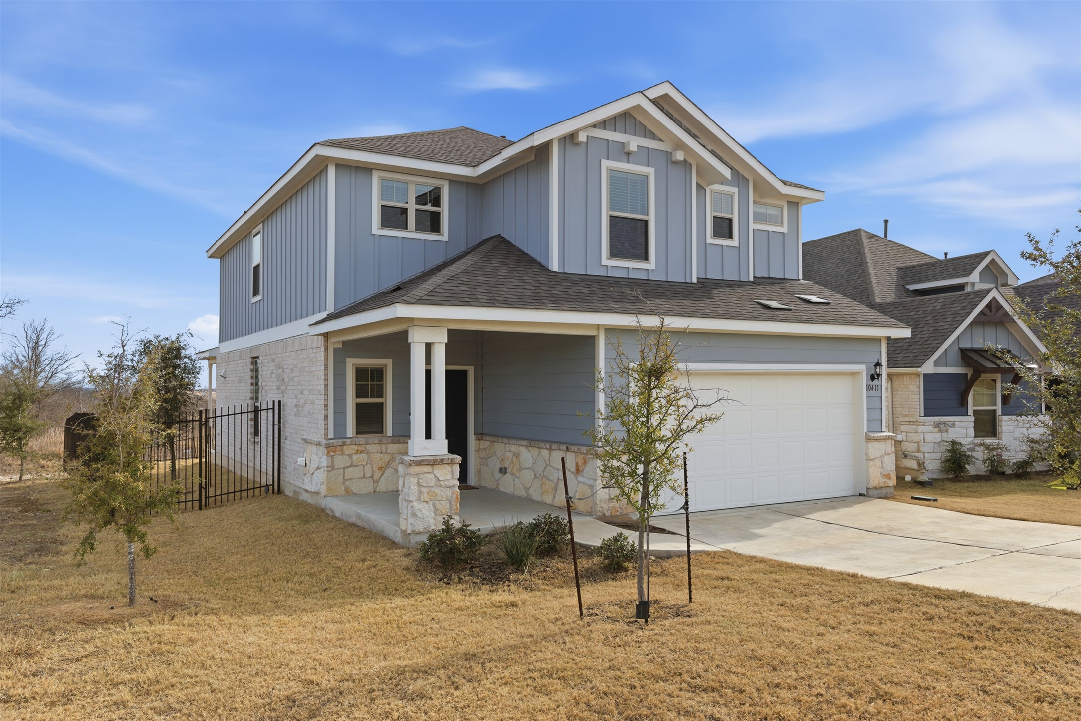 Craftsman inspired home with stone siding, a shingled roof, covered porch, concrete driveway, and board and batten siding