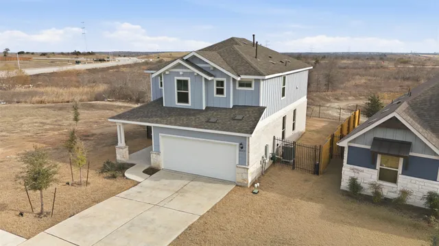 a front view of a house with a yard and mountain view in back