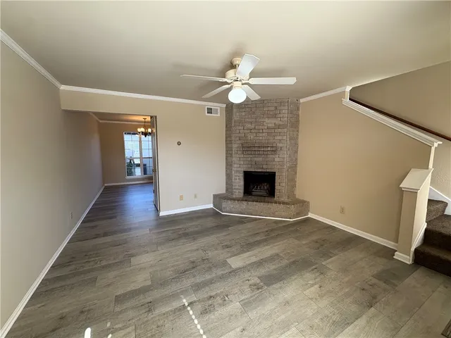 an empty room with windows and fireplace