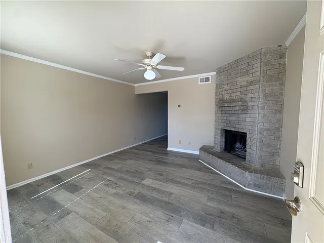 an empty room with a fireplace and fan