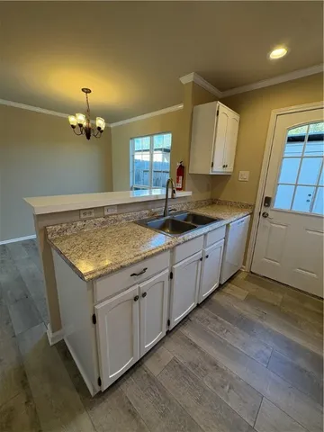 a kitchen with granite countertop a sink and dishwasher with wooden floor