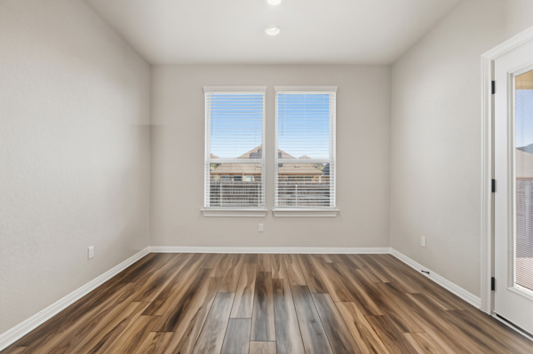 3604 Chaff Lane Pflugerville, TX 78660 - Photo 11 of 26 an empty room with wooden floor and windows