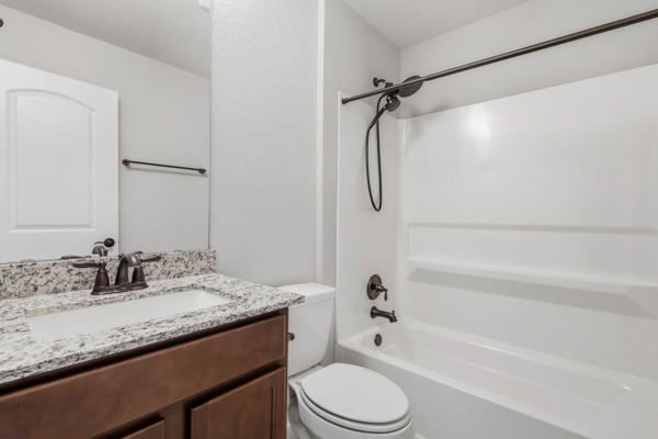 3604 Chaff Lane Pflugerville, TX 78660 - Photo 19 of 26 a bathroom with a granite countertop sink toilet and shower