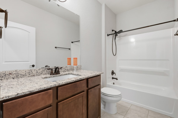 3604 Chaff Lane Pflugerville, TX 78660 - Photo 20 of 26 a bathroom with a granite countertop sink toilet and shower