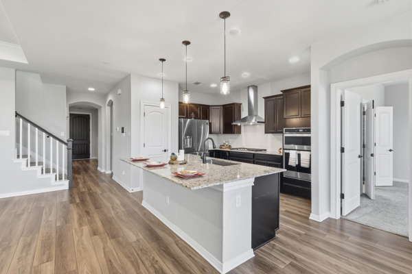 3604 Chaff Lane Pflugerville, TX 78660 - Photo 4 of 26 a kitchen with stainless steel appliances kitchen island a refrigerator and a wooden floor