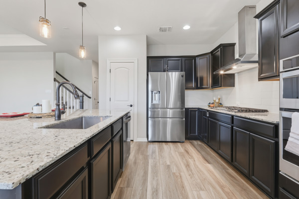 3604 Chaff Lane Pflugerville, TX 78660 - Photo 5 of 26 a kitchen with stainless steel appliances granite countertop a sink refrigerator and microwave