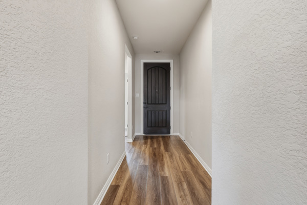 3604 Chaff Lane Pflugerville, TX 78660 - Photo 7 of 26 a view of a hallway with wooden floor