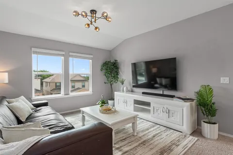 a living room with furniture a flat screen tv and a potted plant