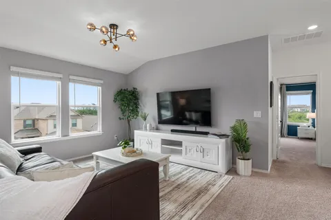 a living room with furniture a flat screen tv and a large window