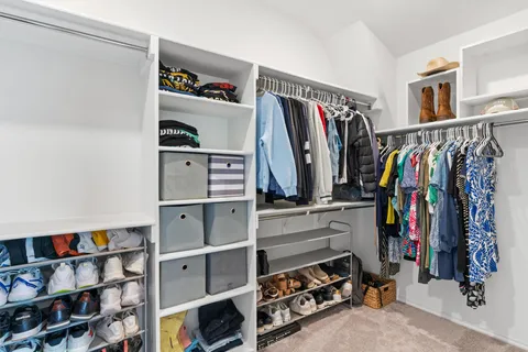 a view of walk in closet with clothes and shoes