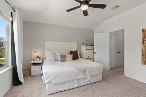 a bedroom with a large bed and a chandelier
