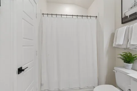 a white toilet sitting next to a shower