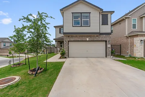 a front view of a house with a yard and a garage