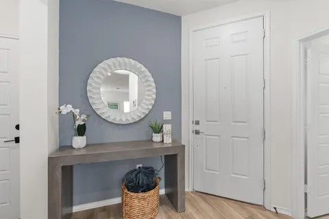a view of a livingroom with wooden floor and a mirror