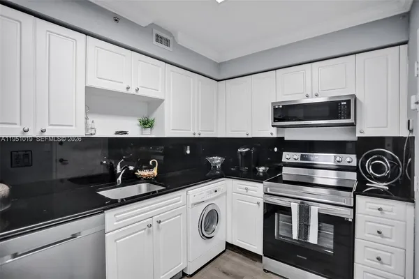 a kitchen with a refrigerator and a stove top oven