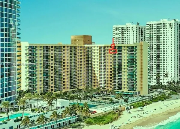 a view of a building with cars parked in front of it