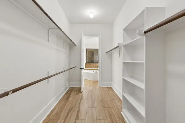 a view of a hallway with wooden floor and staircase