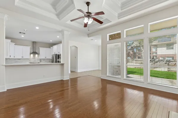a view of an empty room with window and wooden floor