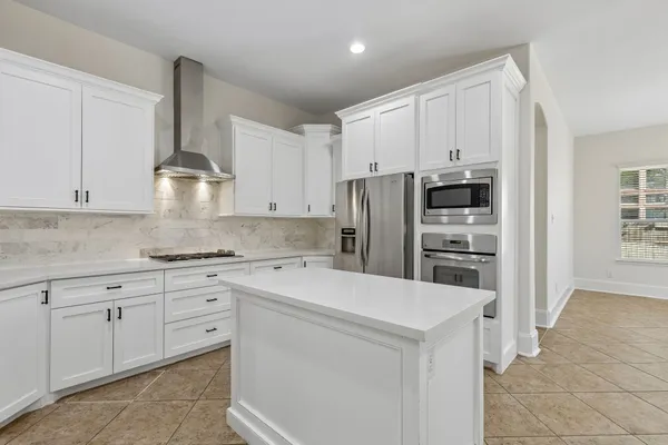a kitchen with stainless steel appliances a refrigerator sink and cabinets