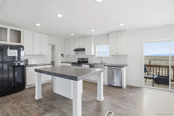 a kitchen with granite countertop white cabinets and appliances