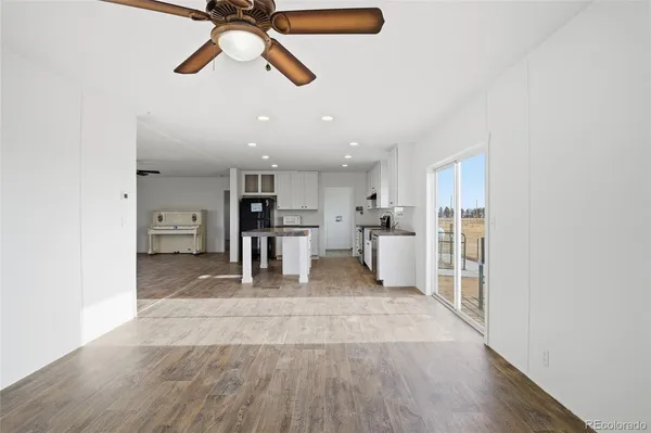 a view of a kitchen with wooden floor and a refrigerator