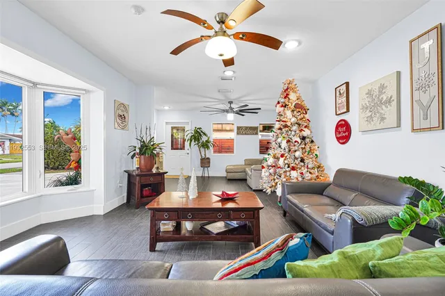 a room with stainless steel appliances kitchen island granite countertop a dining table chairs and a refrigerator