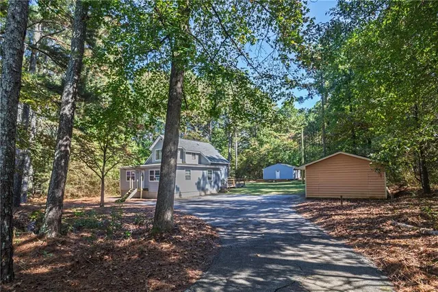 a view of a wooden house with large trees