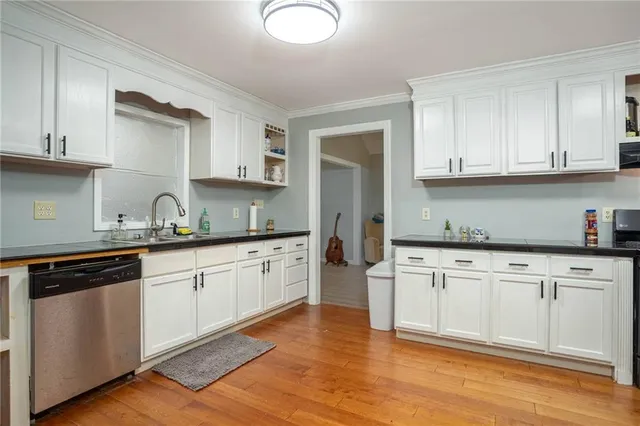 a kitchen with granite countertop white cabinets and white appliances
