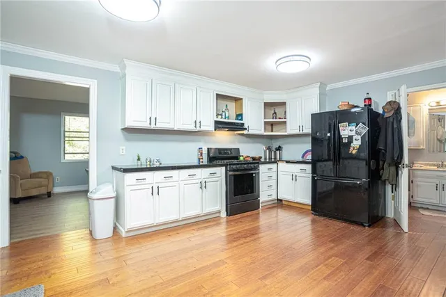 a kitchen with granite countertop a refrigerator and a stove top oven