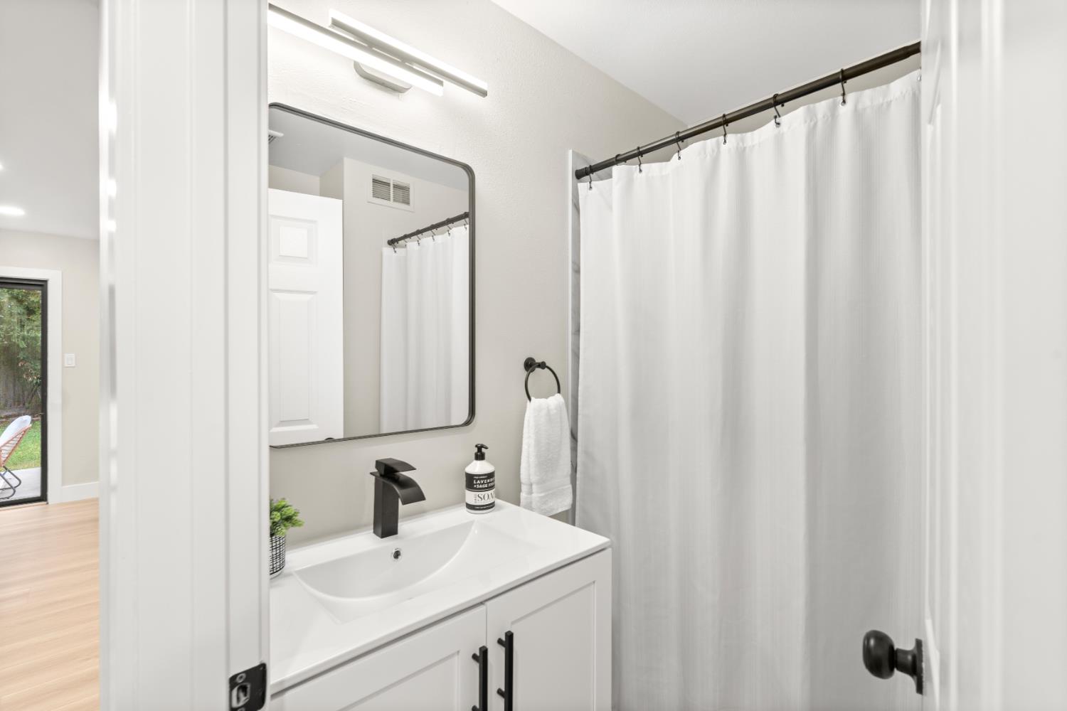 5610 Millburn Street Carmichael, CA 95608 - Photo 20 of 44 a bathroom with a sink a mirror and a shower curtain