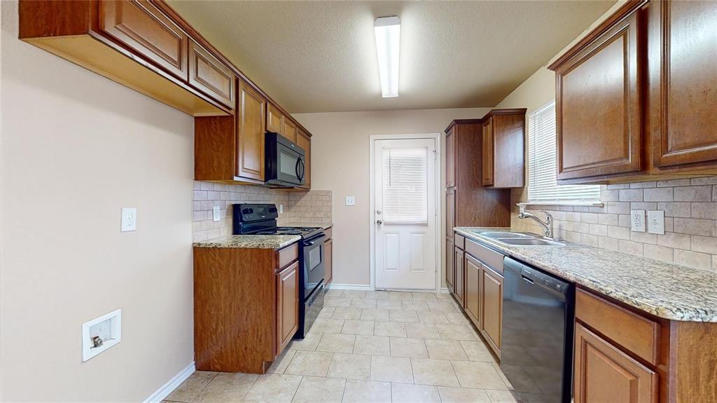812 Parkplace Ridge Princeton, TX 75407 - Photo 4 of 13 Kitchen with black appliances, brown cabinets, tasteful backsplash, light stone countertops, and a textured ceiling