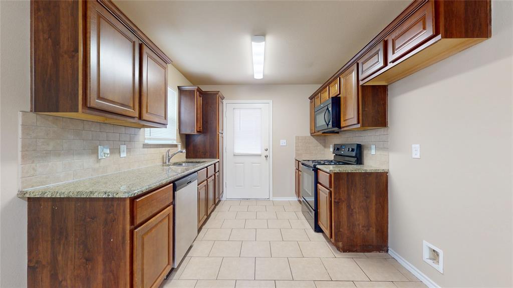 812 Parkplace Ridge Princeton, TX 75407 - Photo 5 of 17 Kitchen featuring black appliances, light stone counters, decorative backsplash, and light tile patterned floors