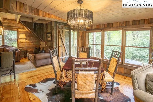a living room with furniture a chandelier and a floor to ceiling window