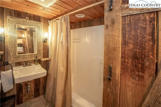 a bathroom with a granite countertop sink a mirror and shower