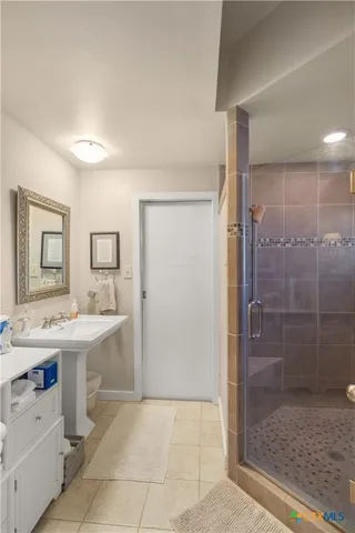 a bathroom with a sink a toilet and shower