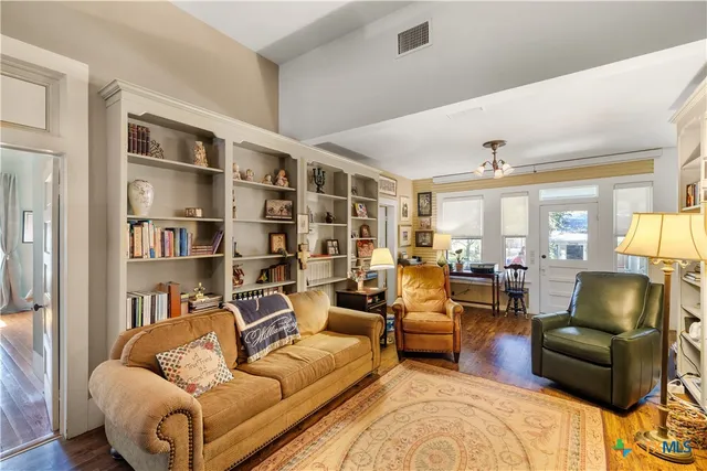 a living room with furniture and a book shelf