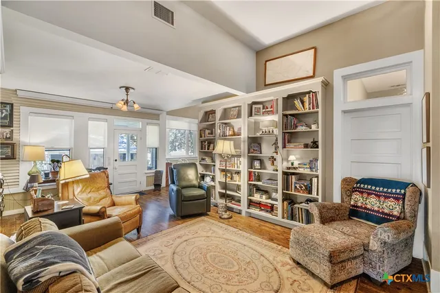 a living room with furniture and a book shelf